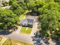 Aerial view of a charming home with a fenced backyard surrounded by lush greenery and mature trees at 105 N 11Th St, Erwin, NC 28339