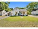 Charming single-story home with a well-manicured lawn, beautiful shutters, and a welcoming front porch at 105 N 11Th St, Erwin, NC 28339