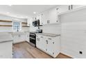 Bright kitchen with white cabinets, stone countertops, stainless steel appliances and wood grain flooring at 105 N 11Th St, Erwin, NC 28339