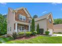Two-story home with stone and siding, featuring a front porch and landscaped yard at 114 Bell Tower Ct, Elon, NC 27244