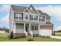Inviting two-story house with a covered entrance, balanced by brick detail and a two car garage at 11412 International Dr, Middlesex, NC 27557