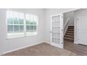 Bright home office with a large window, a glass door, and neutral carpet, perfect for productivity at 11412 International Dr, Middlesex, NC 27557