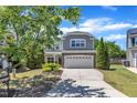 Inviting two-story home with lush green lawn and mature trees, creating a serene suburban setting at 120 Cobblebrook Ct, Holly Springs, NC 27540