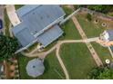 Aerial view of a house with a well-manicured backyard and a gazebo with winding brick paths at 1213 Indian Trail Dr, Raleigh, NC 27609