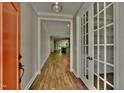 Bright entryway features wood floors, stylish light fixture, and view through french doors and to the open living area at 127 Post Oak Rd, Chapel Hill, NC 27516
