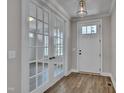 Spacious entryway featuring french doors to the left, white front door, wood floors, and elegant light fixture at 127 Post Oak Rd, Chapel Hill, NC 27516