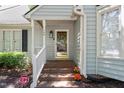 Inviting front porch with brick steps, a white railing, and colorful flowerpots at 140 Heatherwood Dr, Apex, NC 27502