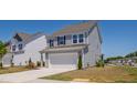 Side view of a modern two-story home with a two-car garage, lawn, and a concrete driveway at 147 Antler Steel Dr, Clayton, NC 27527