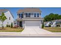 Charming two-story home with a two-car garage, a concrete driveway and manicured front lawn at 147 Antler Steel Dr, Clayton, NC 27527