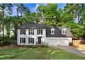 Charming two-story home with black shutters, manicured lawn, and an attached two-car garage at 1609 Falls Ct, Raleigh, NC 27615