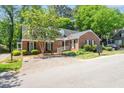 Quaint single story brick home with black shutters and landscaped yard at 1623 Village Glenn Dr, Raleigh, NC 27612