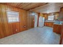 Cozy eat-in kitchen featuring wood paneling, tiled floor, and white appliances at 178 Medford Oakley Rd, Rougemont, NC 27572