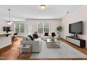 Bright living room featuring modern furniture, a large TV, and hardwood floors, offering a cozy and inviting atmosphere at 1839 Huntley Way, Burlington, NC 27215