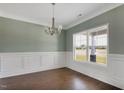 Bright dining room features paneled walls, crown molding, hardwood floors, and a large window at 246 Pretty Run Branch Ln, Wendell, NC 27591