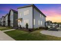 A modern home featuring stylish architecture, well-maintained lawn, and a vibrant sunset backdrop at 270 Wendover Pkwy, Pittsboro, NC 27312