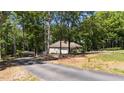 Home exterior with a driveway, boat, and surrounding trees at 3005 Buckhorn Rd, Sanford, NC 27330