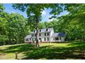 Stately two-story home surrounded by mature trees and a lush lawn, offering a sense of privacy at 318 Hepowil Trce, Hillsborough, NC 27278