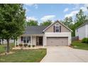 Charming, beige two-story home with a well-manicured lawn and a spacious two-car garage at 334 Huckleberry Loop, Mebane, NC 27302