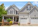 Inviting home exterior showcases a covered porch, dual garage, manicured lawn and delightful landscaping at 3810 Stoneybrook Dr, Durham, NC 27705