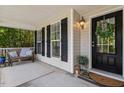 Cozy covered front porch features a bench, decor, and a welcoming front door with stylish wreath at 3810 Stoneybrook Dr, Durham, NC 27705