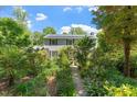 Charming two-story home with a stone path, mature landscaping, and solar panels on the roof at 400 Bowling Creek Rd, Chapel Hill, NC 27514