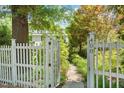 View of white picket fence leading to walkway with garden and the house number 400 on a white post at 400 Bowling Creek Rd, Chapel Hill, NC 27514