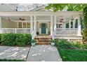 Inviting front porch with white columns and railings, planters, and a teal front door at 415 Waverly Hills Dr, Cary, NC 27519