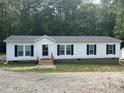 Charming manufactured home featuring white siding, black shutters and a nice gravel driveway at 420 Spring Ln, Henderson, NC 27537