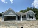 Charming single-story home featuring gray siding, an attached garage, and a welcoming front porch, still under construction at 445 Olivia Crossing Ct # 22, Four Oaks, NC 27524