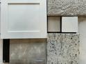 Selection of design materials showing white cabinets, carpet, tile, countertop and wood flooring samples at 445 Olivia Crossing Ct # 22, Four Oaks, NC 27524