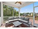 Relaxing screened porch with comfortable seating, a ceiling fan, and views of the backyard and surrounding trees at 46 Waterfall Pointe, Chapel Hill, NC 27517