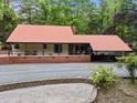 View of house with metal roof and brick foundation in wooded area at 4701 Brock Dr, Hurdle Mills, NC 27541