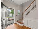 Welcoming foyer featuring hardwood floors, staircase with white wainscoting, and an inviting open entry at 4703 Kings Garden Rd, Raleigh, NC 27612