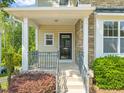Charming front porch with stone columns, gray metal railing, and a welcoming entrance to the home at 4703 Kings Garden Rd, Raleigh, NC 27612