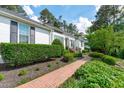 Attractive home exterior showcasing a brick pathway, manicured landscaping, and classic design elements at 4830 North Hills Dr, Raleigh, NC 27612