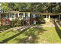 Quaint single-story home featuring a brick facade, a well-manicured lawn, and a welcoming front porch at 502 Burton St, Fuquay Varina, NC 27526