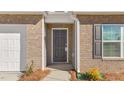 Close-up view of the front door with brick accents and manicured landscaping at 505 Lochalsh Dr, Gibsonville, NC 27249