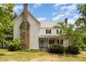 Two-story home showcasing a stone chimney, covered porch and ample outdoor charm at 5062 Dorsey Rd, Oxford, NC 27565