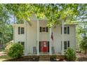 Welcoming front porch with classic columns, a bright red door, and comfortable rocking chairs at 5312 Hallmark Rd, Durham, NC 27712