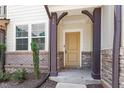 Inviting front porch with stone and brick supports and covered entry at 709 Wickham Ridge Rd, Apex, NC 27539