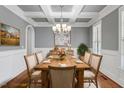 Elegant dining room featuring coffered ceilings, wainscoting, hardwood floors, and a chandelier at 715 Kimbrough St, Raleigh, NC 27608