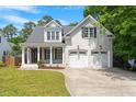 Beautiful two-story home with white brick, a covered porch, and an attached two-car garage at 715 Kimbrough St, Raleigh, NC 27608