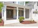 Inviting front porch with brick flooring, white columns, wood beam ceiling, and elegant lantern lighting at 715 Kimbrough St, Raleigh, NC 27608