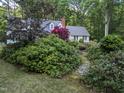 Scenic view of a home surrounded by lush greenery and a stone pathway leading to the entrance at 7401 Walnut Grove Ln, Zebulon, NC 27597