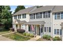 Charming row of townhomes featuring colorful shutters, cozy front porches, and walkways at 831 S White St, Wake Forest, NC 27587