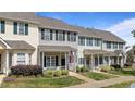 Charming row of townhomes featuring colorful shutters, cozy front porches, and walkways at 831 S White St, Wake Forest, NC 27587
