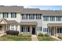 Charming townhome featuring gray siding, black shutters, a cozy front porch, and an American flag at 831 S White St, Wake Forest, NC 27587