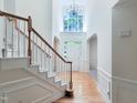 Bright and airy foyer featuring a staircase, hardwood floors, and a large window above the door at 102 Downing Forest Pl, Cary, NC 27519