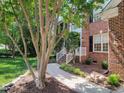Inviting front entrance of a brick home, framed by mature landscaping and a well-maintained walkway at 102 Downing Forest Pl, Cary, NC 27519