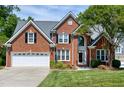 Charming brick home featuring manicured lawn, two-car garage, and traditional architectural details at 105 Bardsey Ct, Cary, NC 27513